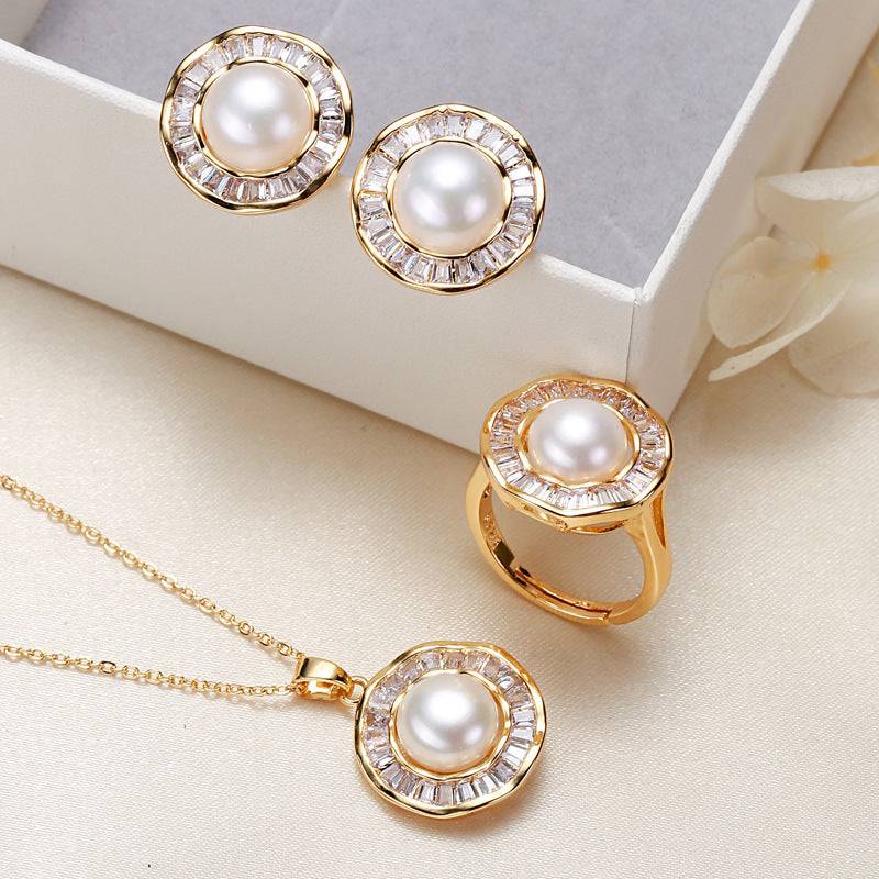 Elegant pearl necklace, ring, and earrings set in gold ornament design.