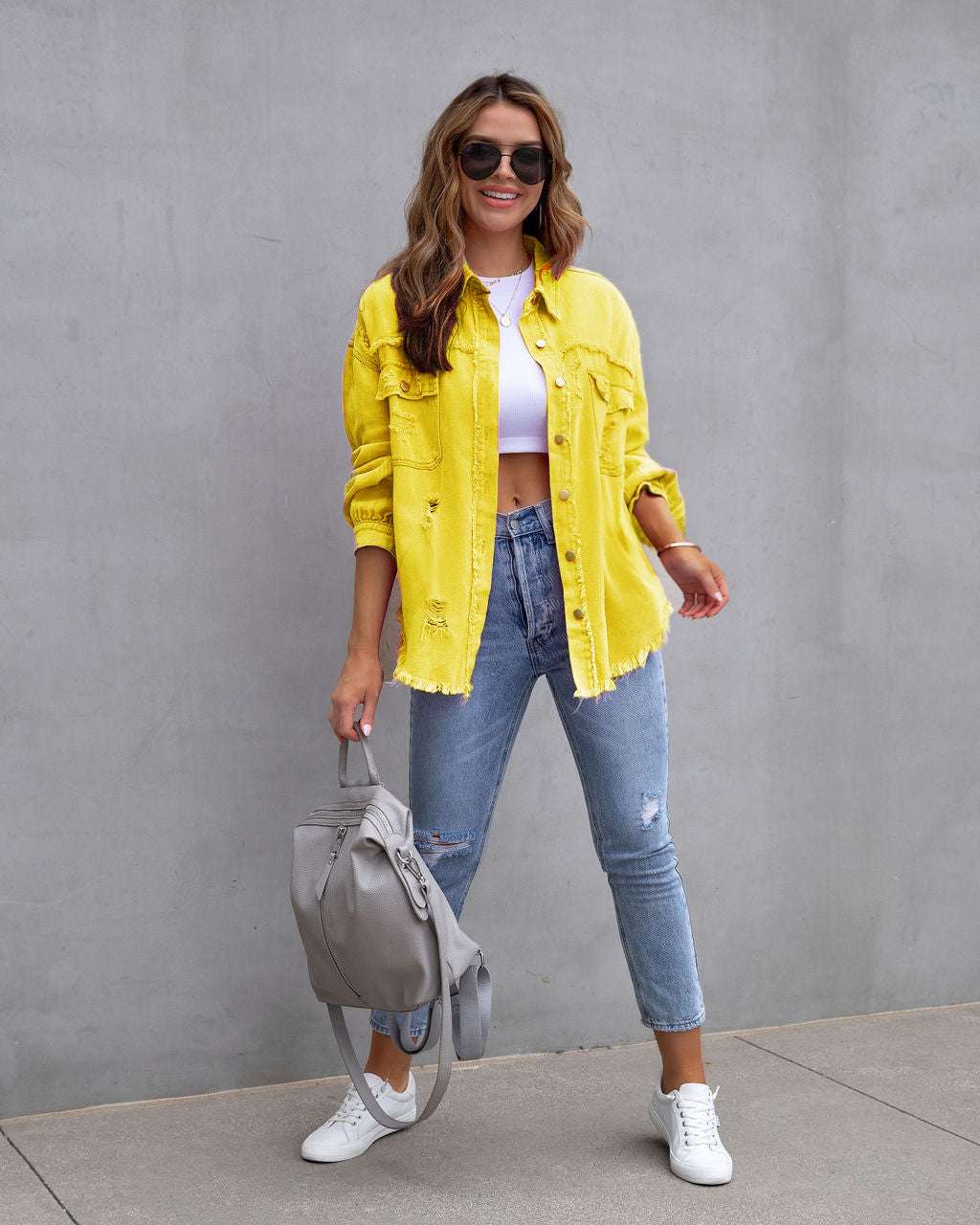 Fashion ripped shirt jacket in yellow, worn by a woman with casual jeans and sneakers, styled for autumn and spring.