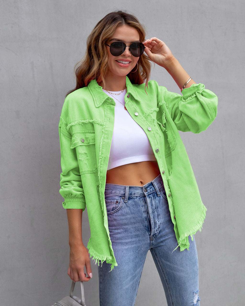 Fashionable ripped shirt jacket in bright green, showcasing a casual and stylish look for women.