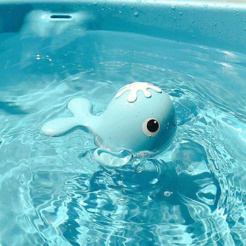 Blue whale-shaped children bathing toy floating in water.