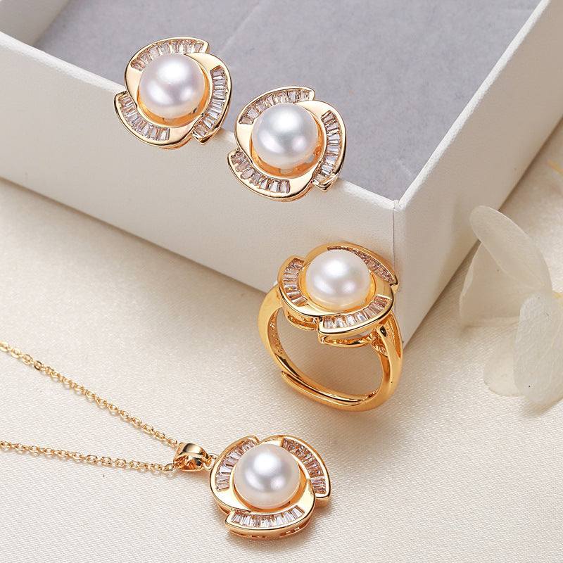 Pearl necklace, ring, and earrings set with gold accents displayed in a jewelry box.