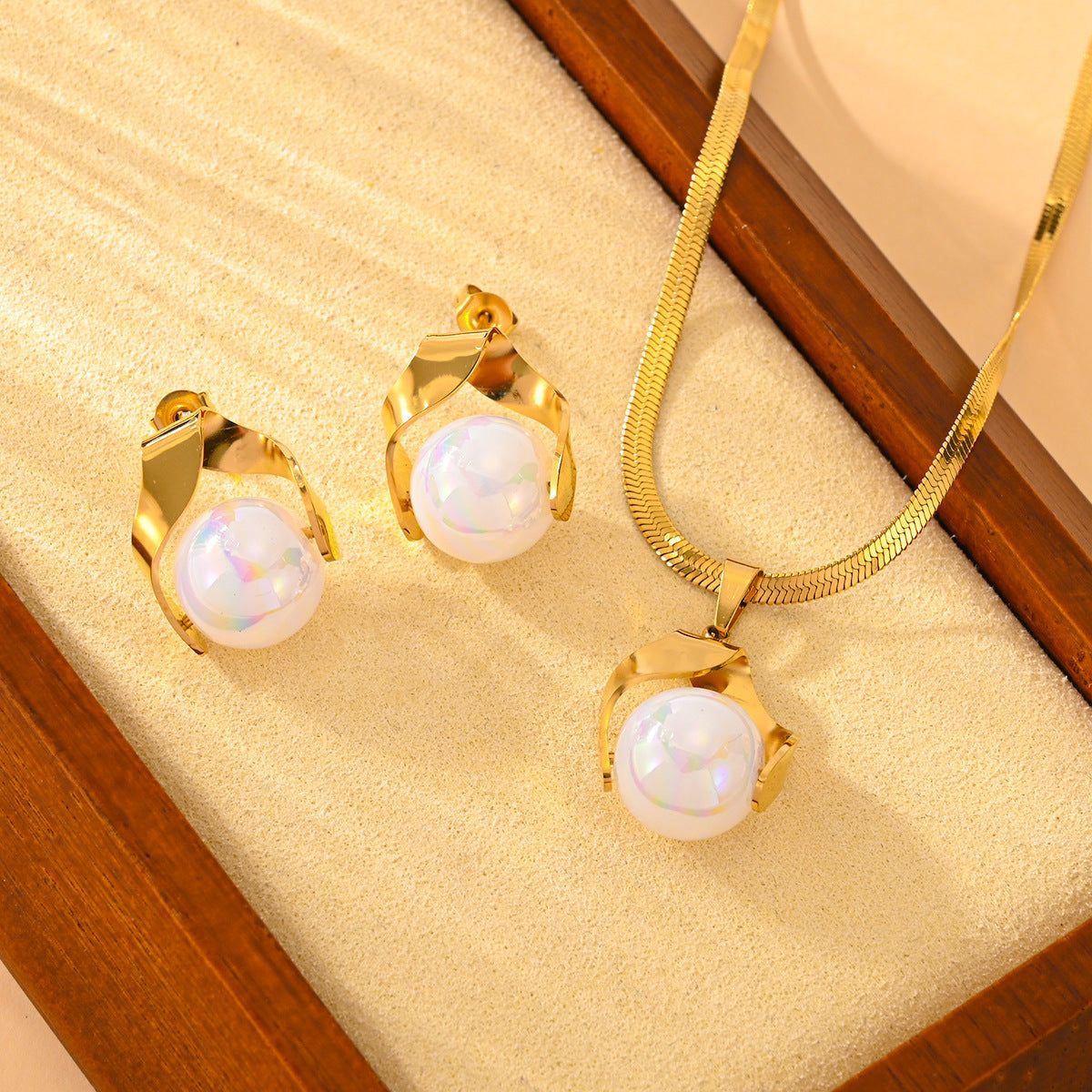 Pearl earrings and necklace set with gold electroplating on a jewelry box.